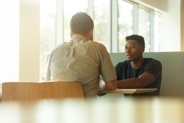 Foto von LinkedIn Sales Navigator: https://www.canva.com/photos/MADGv1d0FsQ-two-men-talking-while-sitting-beside-table/